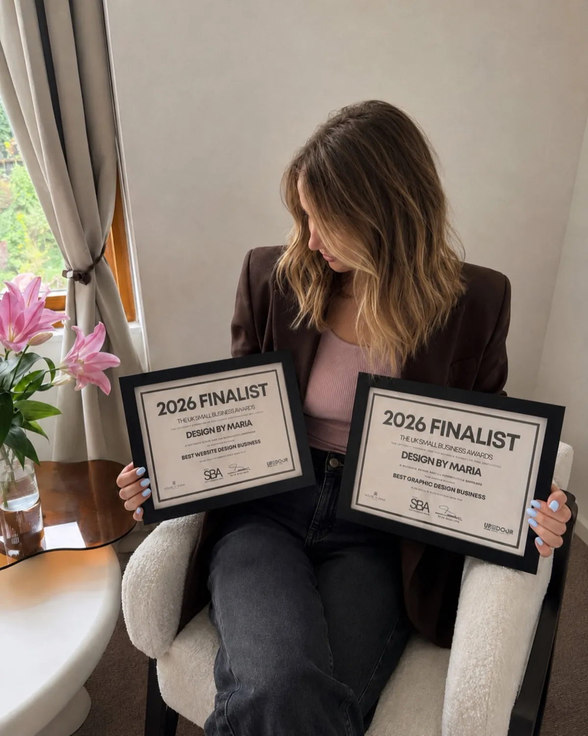 Maria Glowacka, founder of Design by Maria, holding two UK Small Business Awards 2026 Finalist certificates